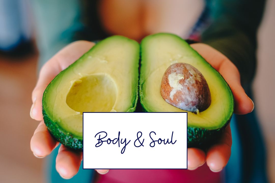 Frau hält zwei Avocadohälften – gesunde Fette für Hormone, Figur und Stoffwechsel